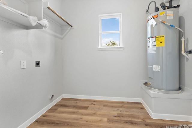 laundry room featuring water heater, hardwood / wood-style flooring, and hookup for an electric dryer