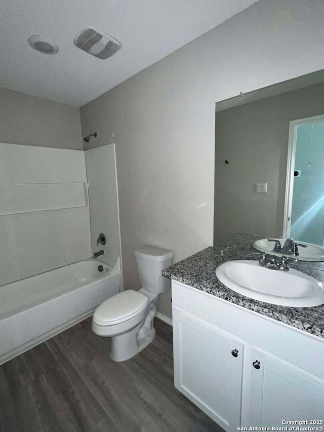 full bathroom featuring hardwood / wood-style floors, vanity, toilet, and shower / washtub combination