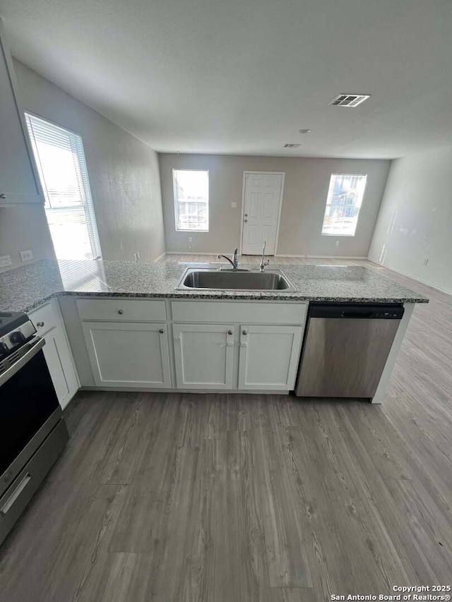 kitchen featuring light stone counters, sink, white cabinetry, and stainless steel appliances