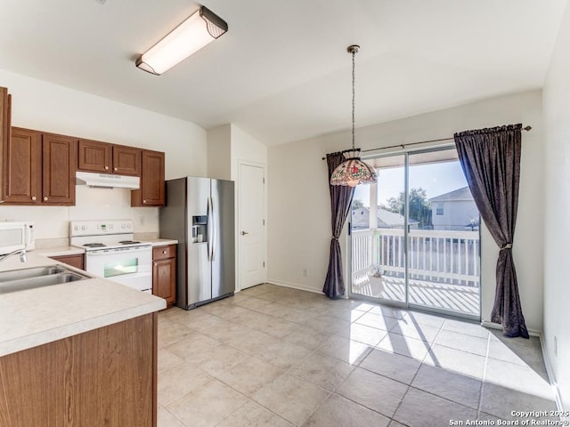 kitchen with sink, white appliances, and hanging light fixtures