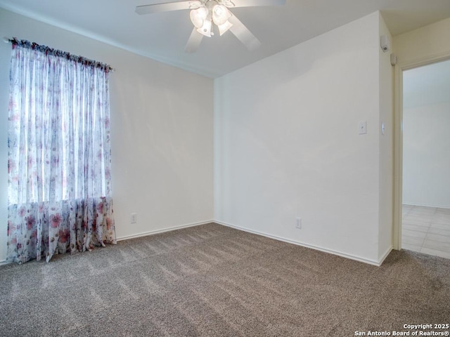 carpeted spare room featuring ceiling fan