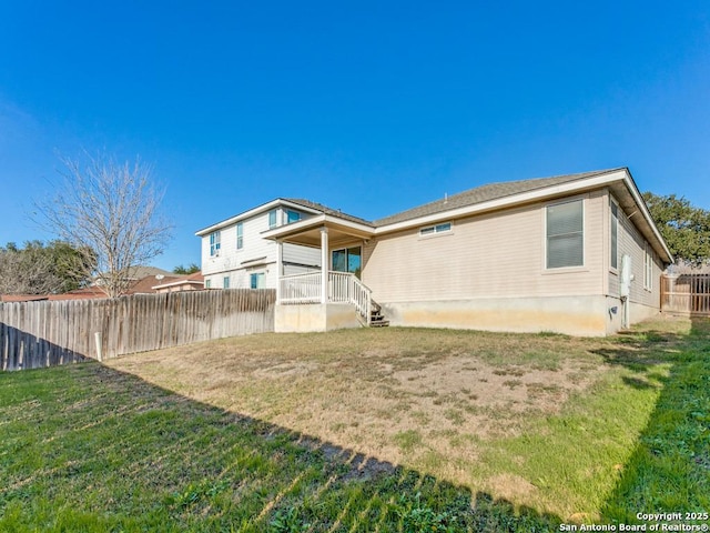 rear view of house featuring a lawn