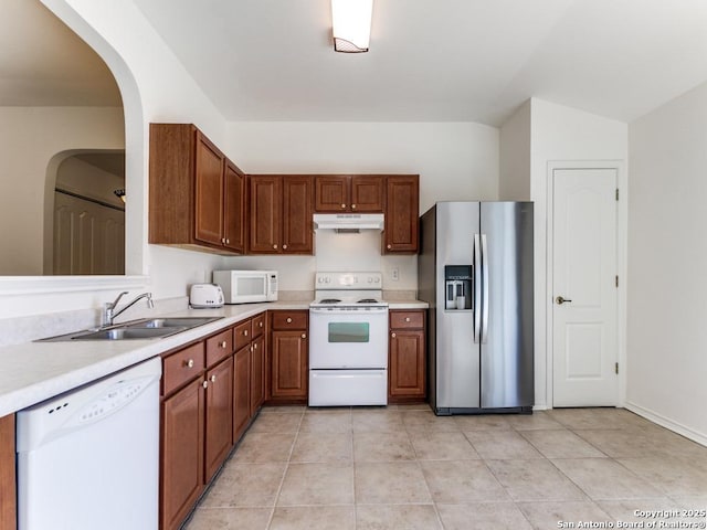 kitchen with sink, light tile patterned floors, and white appliances