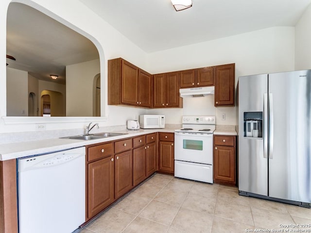 kitchen featuring white appliances, sink, and light tile patterned floors