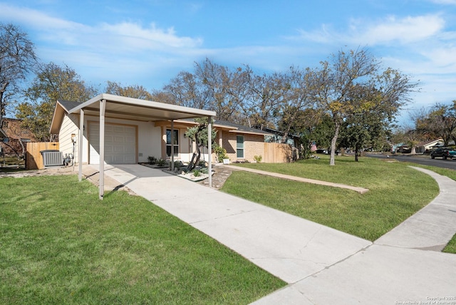 ranch-style house with a garage, central air condition unit, and a front yard