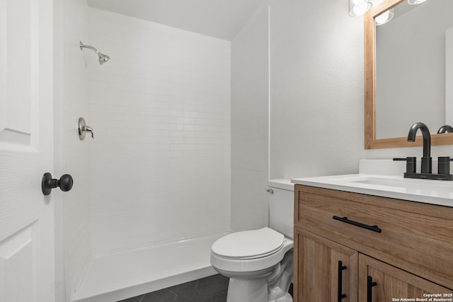 bathroom with tile patterned flooring, a shower, vanity, and toilet