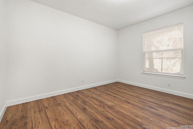 empty room with dark hardwood / wood-style flooring