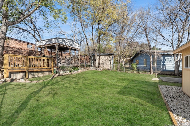 view of yard with a gazebo, a wooden deck, and a storage unit