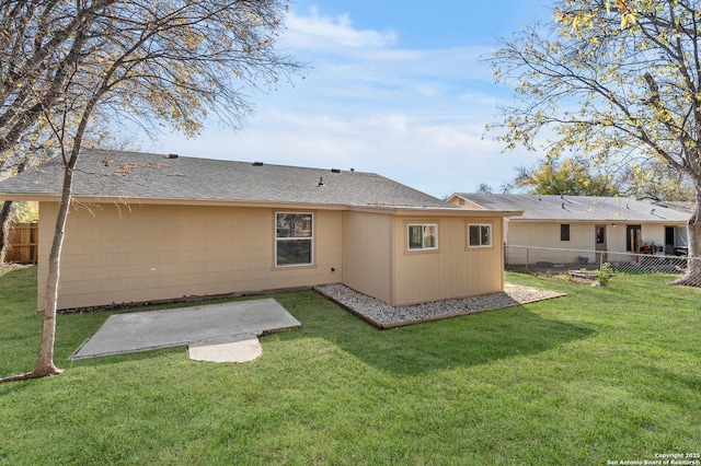 rear view of property featuring a yard and a patio area