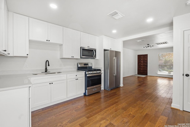 kitchen featuring white cabinets, dark hardwood / wood-style flooring, sink, and appliances with stainless steel finishes