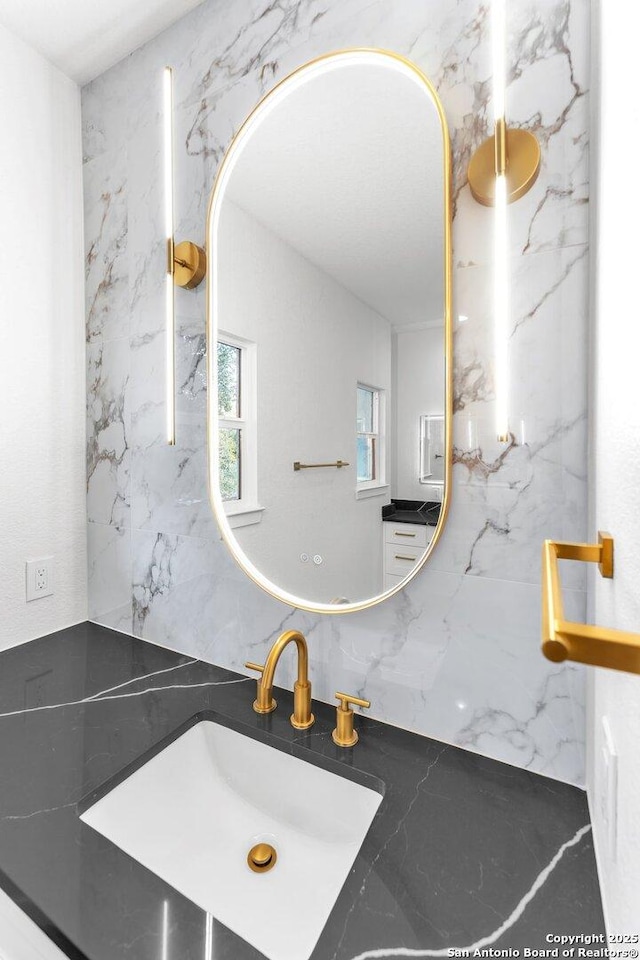 bathroom with backsplash, tile walls, and sink