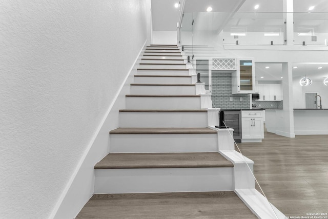 staircase featuring hardwood / wood-style flooring and sink