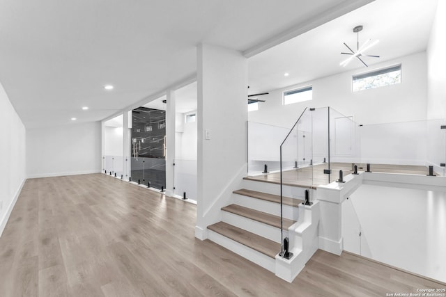 staircase with wood-type flooring and ceiling fan