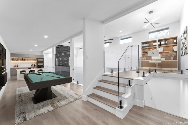 recreation room featuring bar area, ceiling fan, light wood-type flooring, and billiards