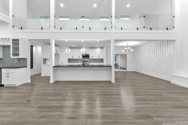 unfurnished living room featuring wood-type flooring and a chandelier