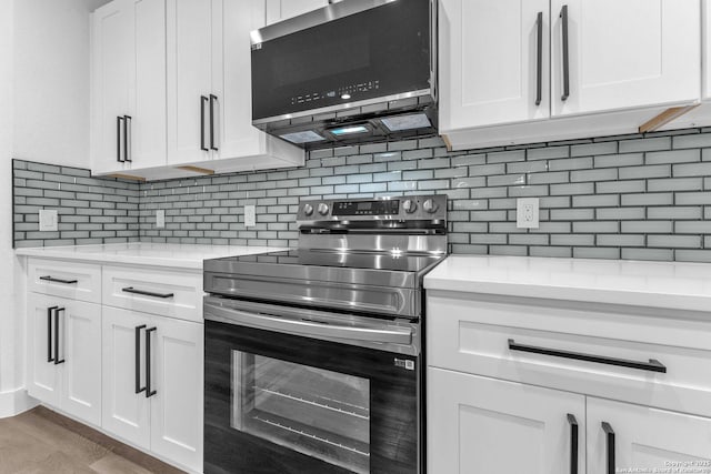 kitchen featuring backsplash, white cabinets, light hardwood / wood-style flooring, appliances with stainless steel finishes, and light stone counters