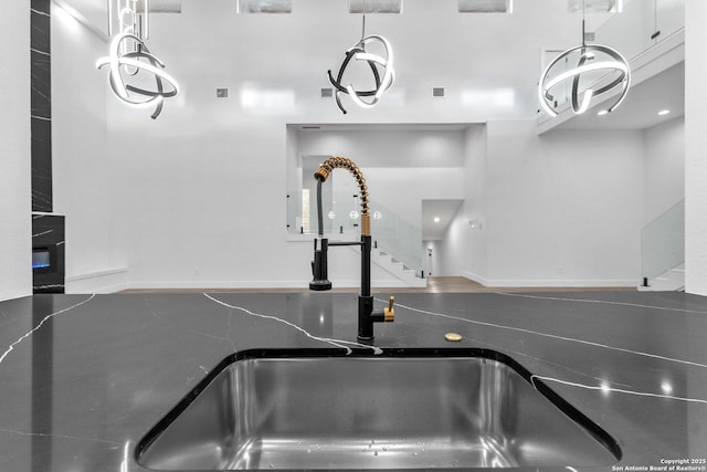 room details with pendant lighting, white cabinetry, and sink