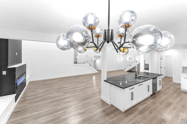 kitchen featuring white cabinetry, sink, dishwasher, and light hardwood / wood-style floors