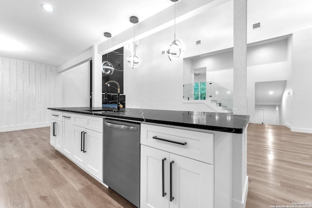 kitchen featuring pendant lighting, sink, stainless steel dishwasher, light wood-type flooring, and white cabinetry