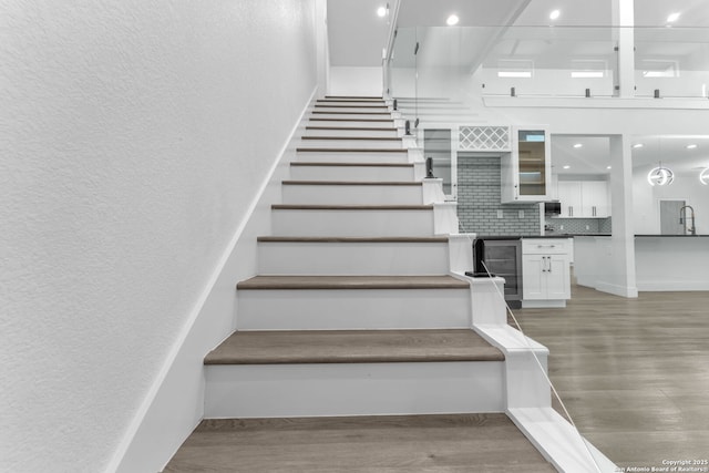 stairway featuring hardwood / wood-style flooring and sink