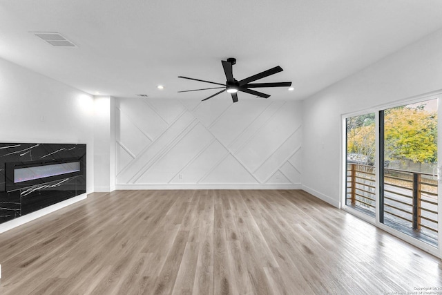 unfurnished living room featuring ceiling fan and light wood-type flooring