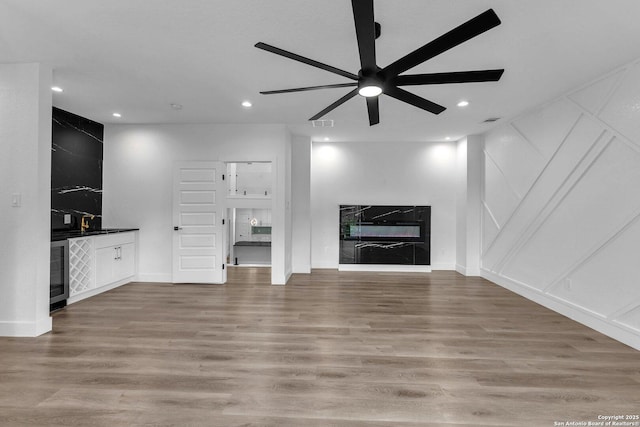 unfurnished living room featuring wood-type flooring and ceiling fan