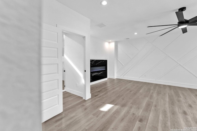 unfurnished living room with ceiling fan and light hardwood / wood-style floors