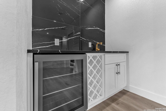 bar featuring white cabinetry, wood-type flooring, sink, and wine cooler