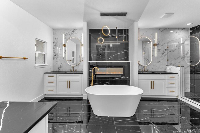 bathroom with vanity, a textured ceiling, and independent shower and bath