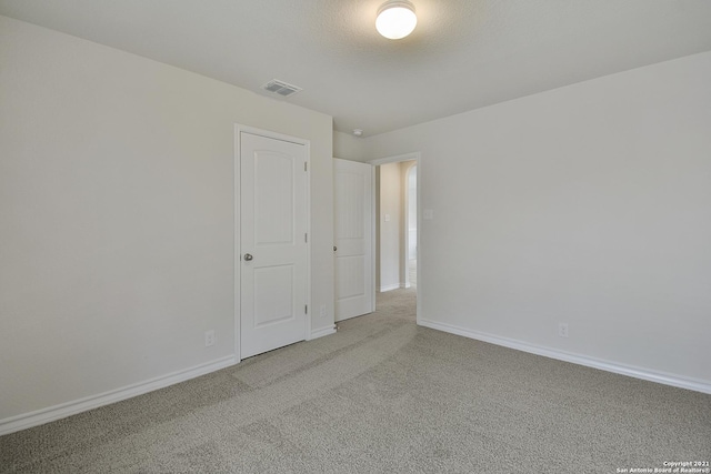 spare room featuring carpet floors and a textured ceiling