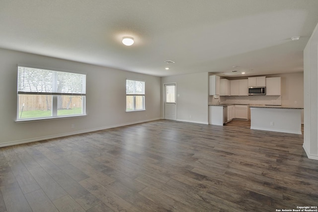 unfurnished living room with dark hardwood / wood-style flooring