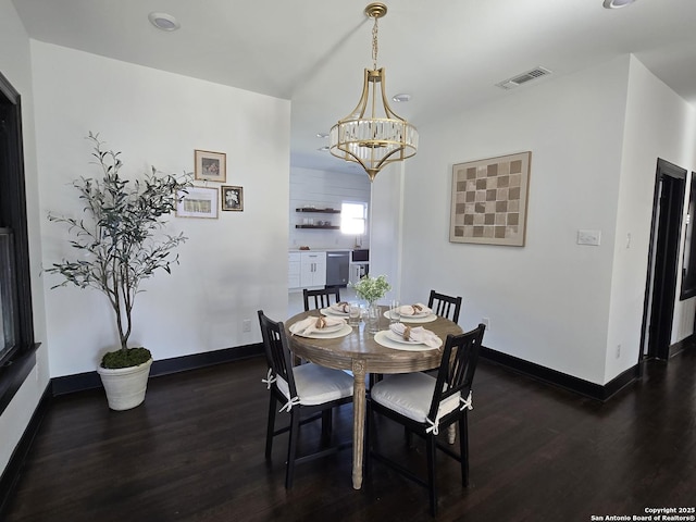 dining area featuring dark hardwood / wood-style flooring and a notable chandelier