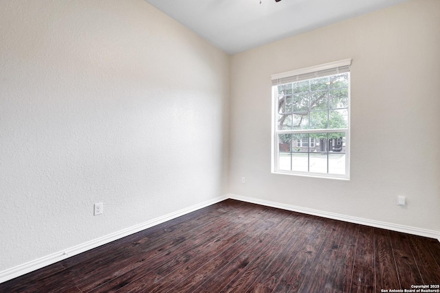 spare room featuring hardwood / wood-style floors and vaulted ceiling