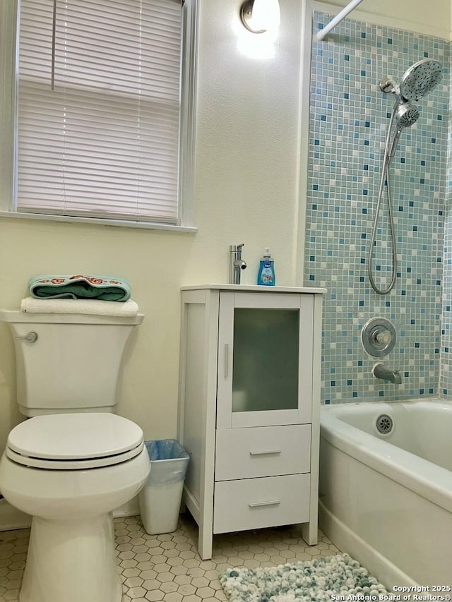 bathroom featuring tile patterned floors, tiled shower / bath combo, and toilet