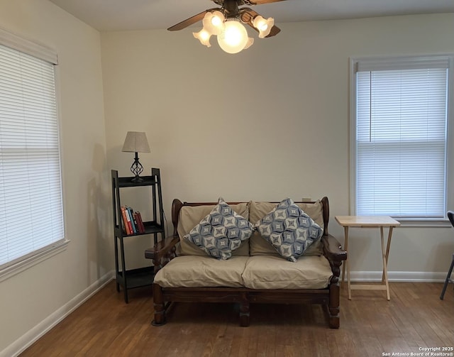 living area with a wealth of natural light, ceiling fan, and hardwood / wood-style flooring