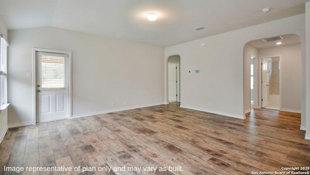 empty room featuring wood-type flooring and lofted ceiling