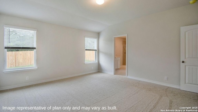 carpeted spare room featuring vaulted ceiling