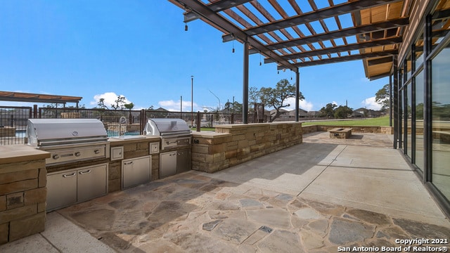 view of patio / terrace with a pergola, a grill, and exterior kitchen