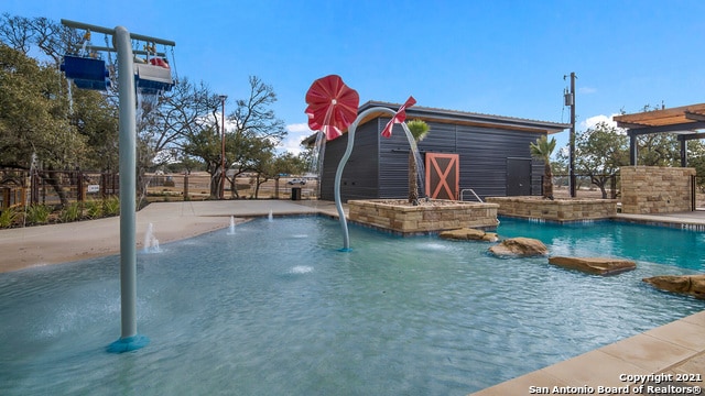 view of swimming pool with pool water feature