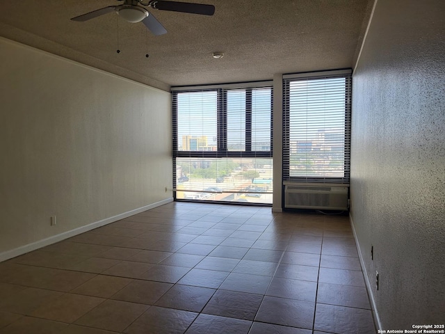 empty room with plenty of natural light, ceiling fan, a textured ceiling, and a wall unit AC