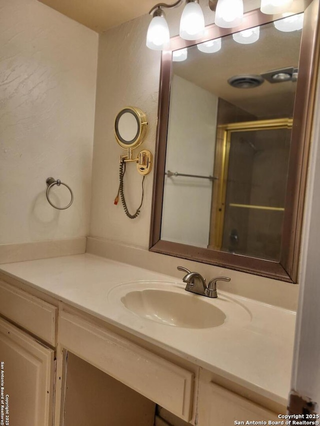 bathroom featuring vanity and a shower with shower door