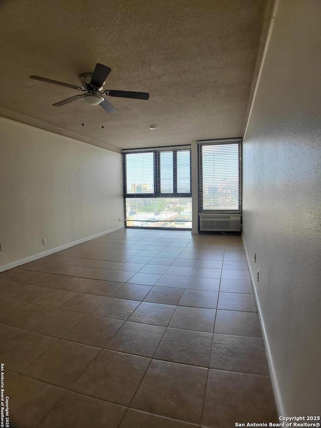 tiled empty room featuring ceiling fan and a textured ceiling