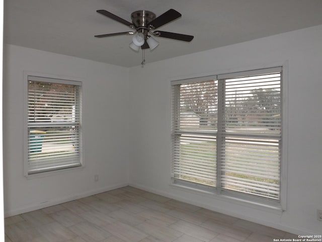 spare room featuring ceiling fan and a healthy amount of sunlight