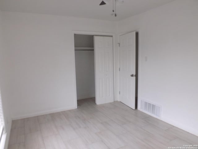 unfurnished bedroom featuring ceiling fan and a closet