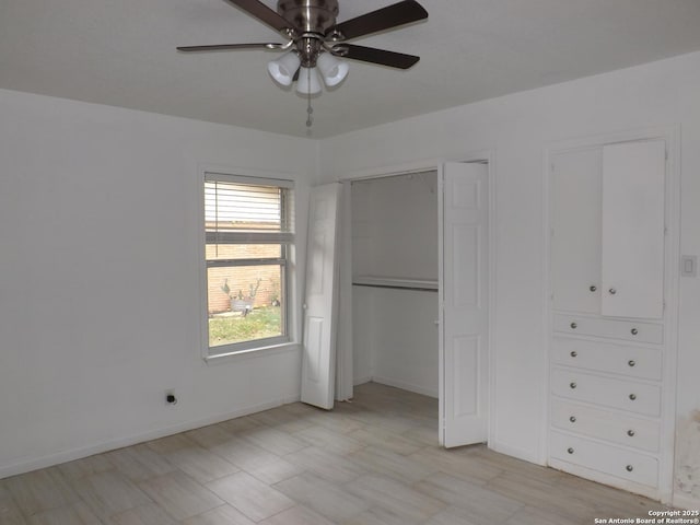 unfurnished bedroom with ceiling fan and multiple closets