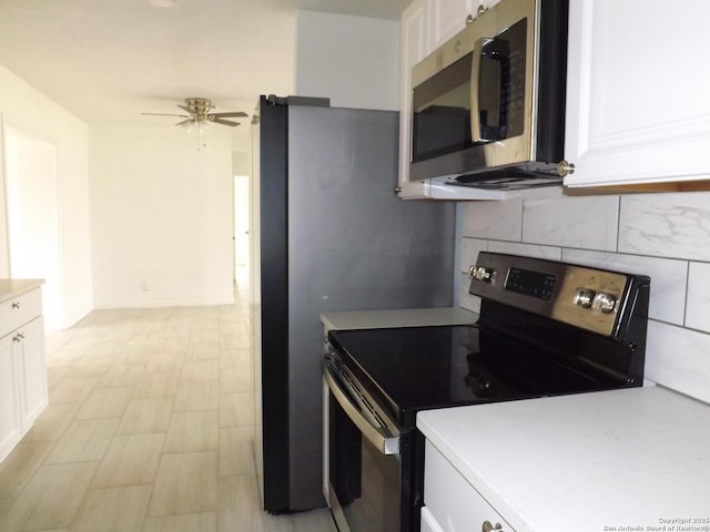 kitchen featuring backsplash, white cabinetry, black / electric stove, and ceiling fan