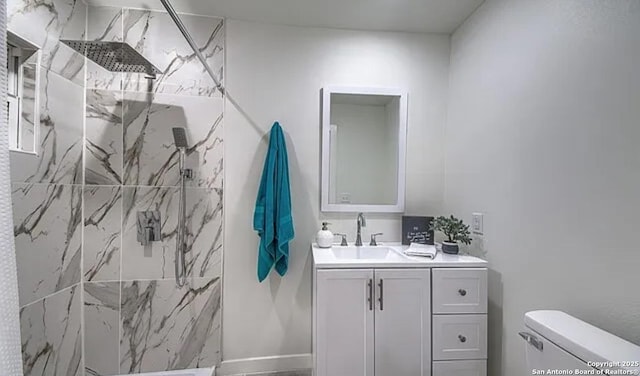 bathroom featuring vanity, toilet, and tiled shower