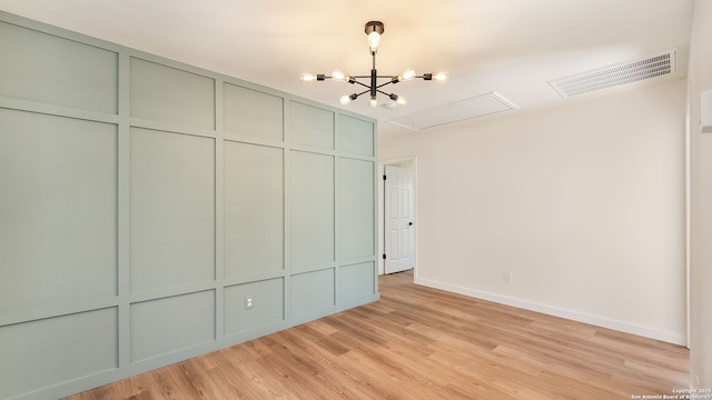 unfurnished bedroom with light hardwood / wood-style flooring and a chandelier