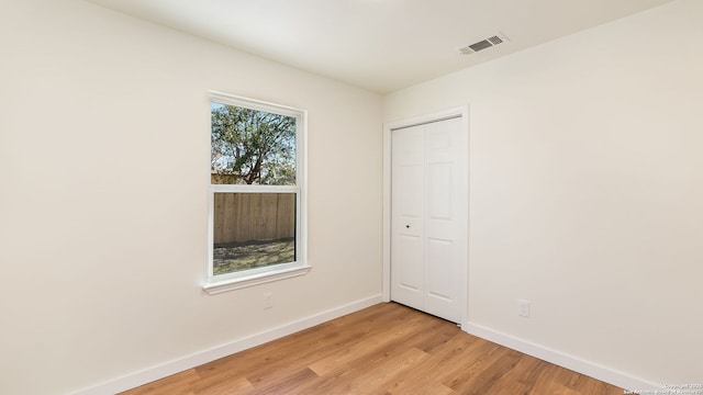 unfurnished bedroom featuring a closet and light wood-type flooring