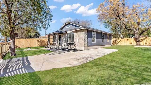 rear view of house with a lawn and a patio